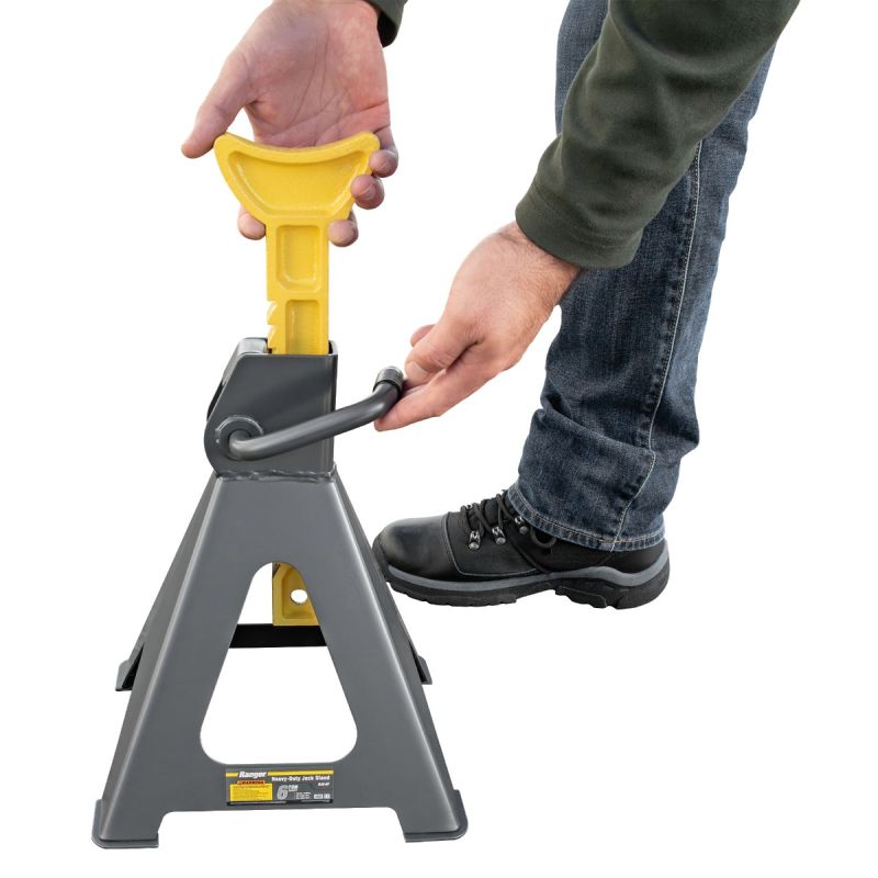 Mechanic using a car jack and jack stands safely to lift a vehicle for brake repair, tire change, or routine maintenance.