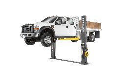 Full system view of the BendPak XPR-12FDL lifting a work truck on its 12,000-lb floor-plate two-post platform, designed for commercial bays and fleet service. SKU 5175403